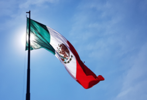 Picture of a Mexican flag against a blue sky