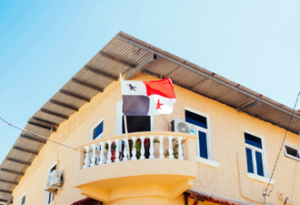 Picture of a blue sky and a house with the flag of Panama