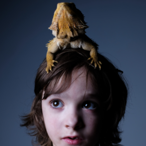 Wish Child Cassandra pictured with a reptile on her head