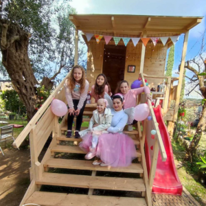Wish child Lilian and friends on the steps of her tree house