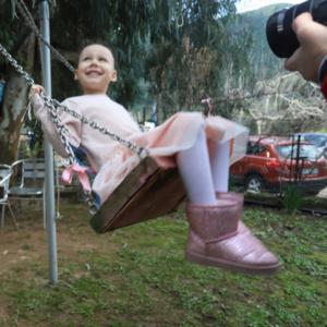 Lilian smiles as she sits on a swing