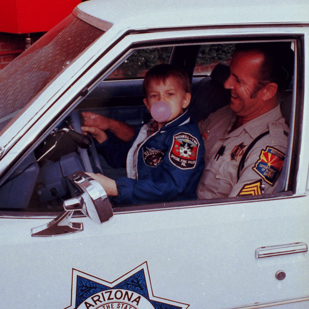 The child who inspired the founding of Make-A-Wish, Chris Grecius on his wish day in an Arizona state patrol car with a state trooper