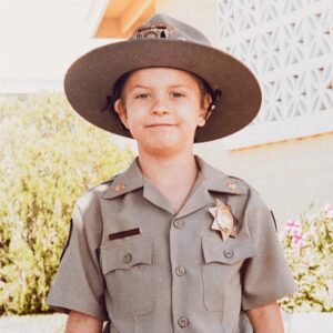 A young boy with a police officer costume and patrol man's hat