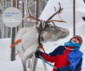 Boy standing with a reindeer in the snow