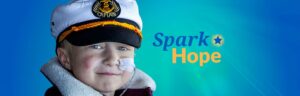 Spark Hope logo on decorative background with wish child Morris wearing sailor had