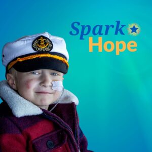 Spark Hope logo on decorative background with wish child Morris wearing sailor had