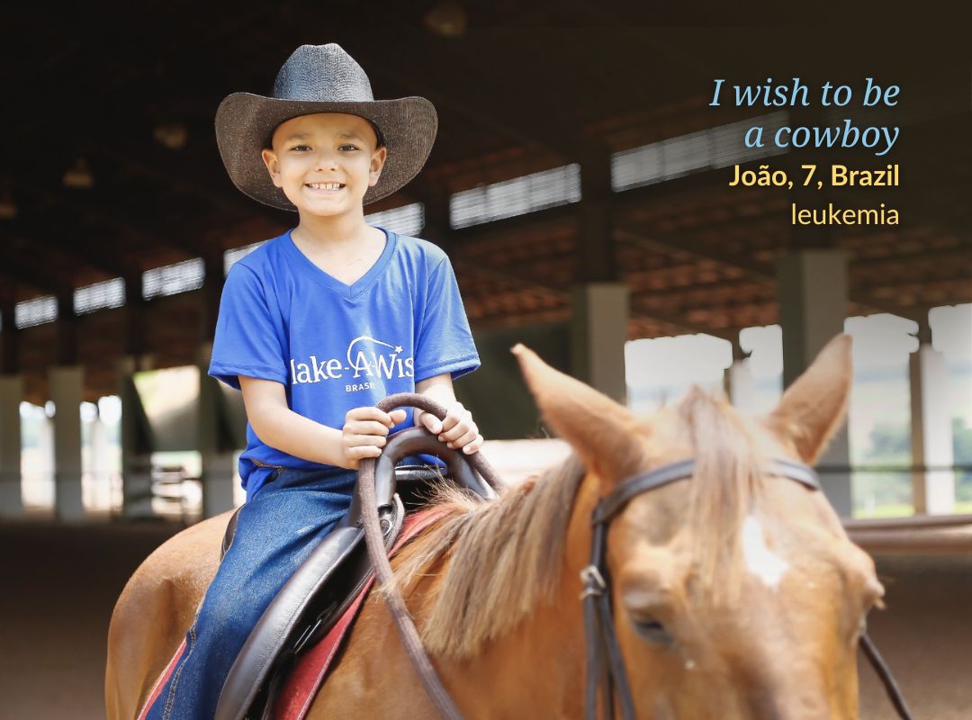 Boy in cowboy hat sits on a horse and smiles to camera